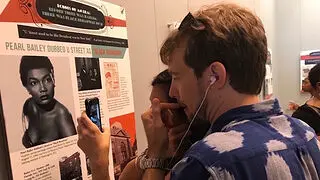 Visitors use an app to interact with a pop-up museum exhibit.