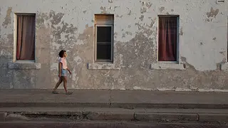 Morgan Vickers walks in front of an abandoned building in Shamrock, Texas.