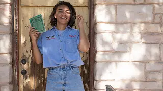 Morgan Vickers poses in front of Cactus Motel, New Mexico, with a copy of a Green Book.
