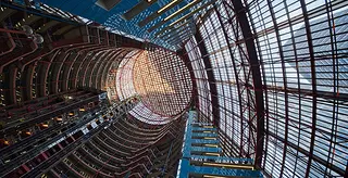 Looking up at the Thompson Center which has clean grid lines leading up to a circular ceiling c. 2022.